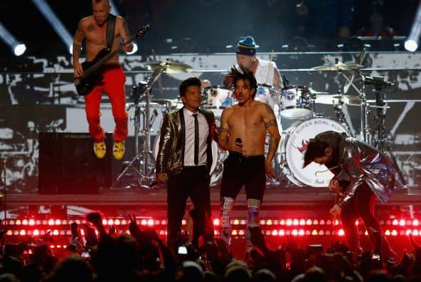 Un cuidado estilismo retro, una banda llena de energía y una particular mezcla de soul y rock sirvieron al cantante Bruno Mars para cautivar a la millonaria audiencia del Super Bowl durante el descanso de la gran cita anual del fútbol americano. Mars, de sólo 28 años y sobre quien planeaba la duda de si sería capaz de enfrentarse a un escenario de tal calibre, optó por un show directo y contundente. Tras una breve introducción a cargo de un coro de niños, un espectacular solo de batería sirvió para abrir el fuego y dar paso rápidamente al gran éxito "Locked Out of Heaven". Impecablemente vestido con una chaqueta dorada, despachó el tema junto a una banda con una amplia sección de viento que se lució en las coreografías. Sin más dilación, Mars descargó su segundo hit, "Treasure", y a continuación demostró su capacidad para fusionar el soul, el pop y el rock integrando en su espectáculo a los Red Hot Chili Peppers. La banda de Anthony Kiedis y Flea puso a saltar a todo el estadio Metlife con su clásico "Give it Away". Los rockeros californianos, a pecho descubierto como manda la tradición, solo necesitaron un par de minutos para demostrar que siguen en buena forma y ceder de nuevo el protagonismo a Mars.