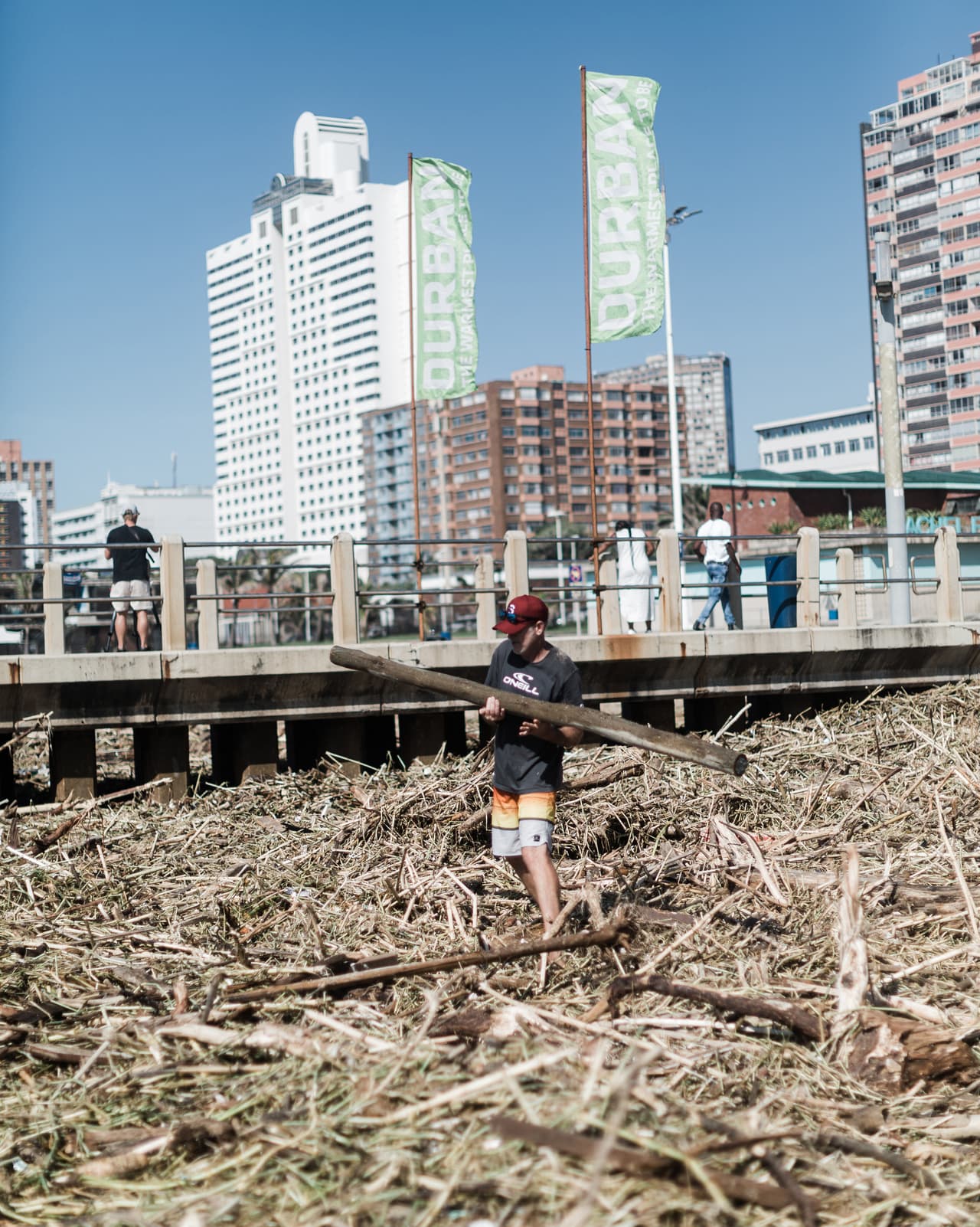 Voluntarios limpian los escombros masivos en North Beach. Puseletso Mofokeng, miembro del Instituto Nacional de Meteorología explicó que aunque la lluvia actual es menos abundante, como el suelo ya está saturado de agua, podría haber muchísimas más inundaciones".
<br>