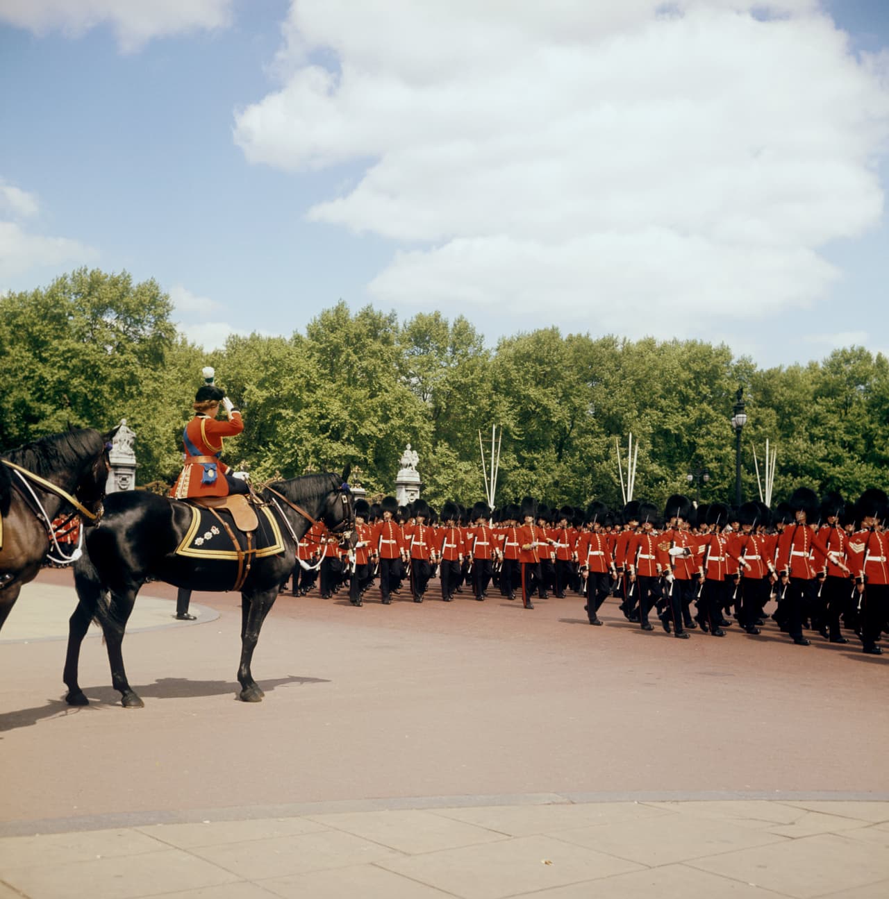 Por tradición, la celebración oficial del cumpleaños de la reina es el segundo sábado de junio, cuando hay un desfile militar de los guardias reales, con sus uniformes rojos y sombreros de piel de oso. El desfile es conocido como
<b>"Trooping the Colour"</b>. En la imagen, se puede ver
<b>el de 1973</b>, con la reina Isabel saludando desde un caballo a los guardias reales.
