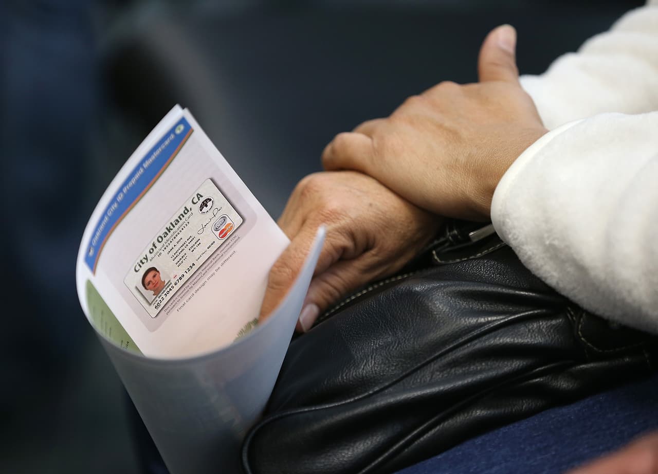 OAKLAND, CA - FEBRUARY 01: A woman holds a brochure on the new Oakland Municipal identification card on February 1, 2013 in Oakland, California. Oakland became the first city in the nation to offer a municipal identification card that also doubles as a debit card. The card is available to all city residents as well as illegal immigrants and will allow people to use the debit card function to avoid check-cashing fees. The city expects to issue at least 6,000 of the $15 cards in the first year. (Photo by Justin Sullivan/Getty Images)