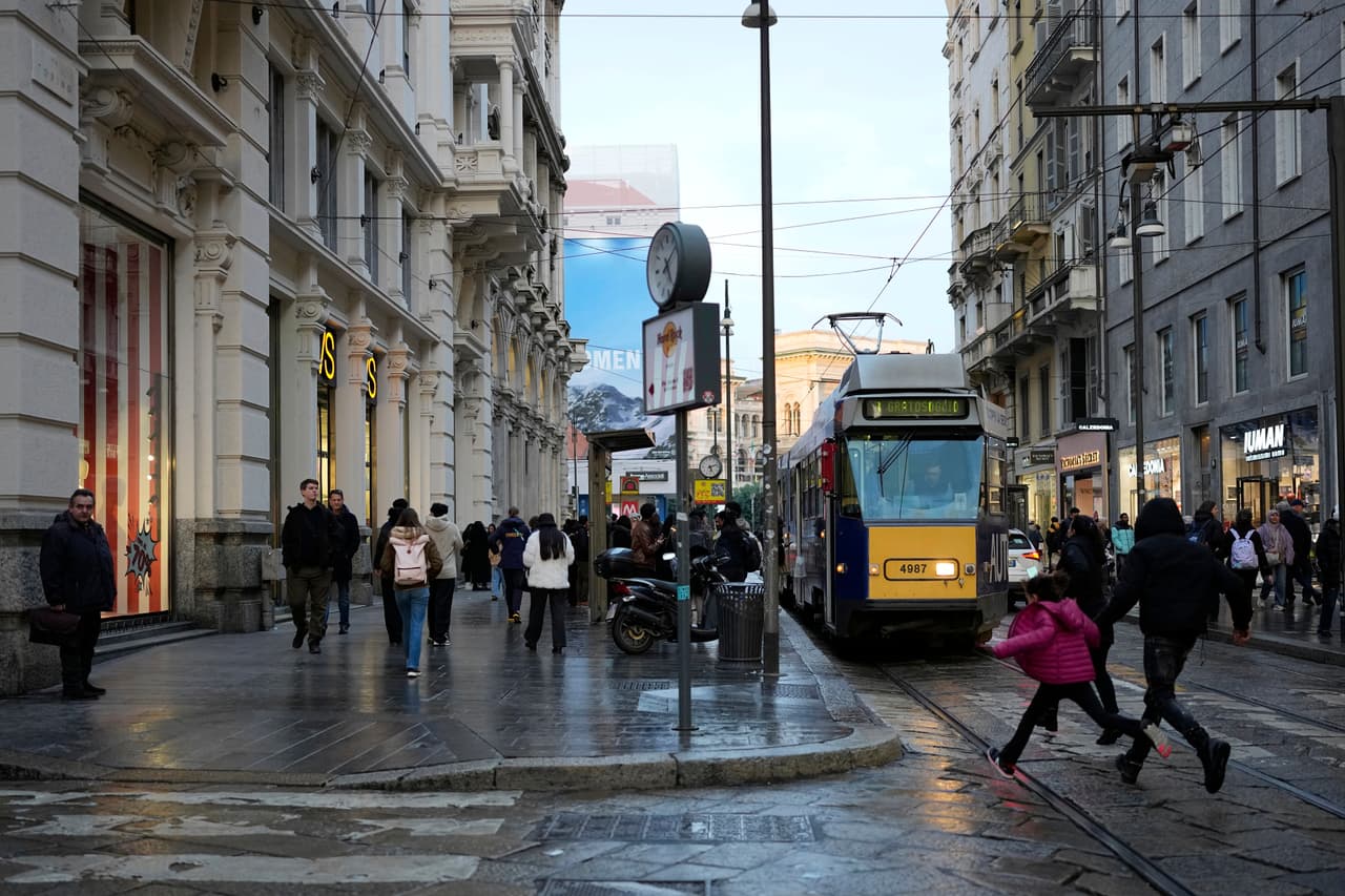 La gente camina por una calle en Milán, Italia, el lunes 9 de febrero de 2026. (Foto AP/Christophe Ena)