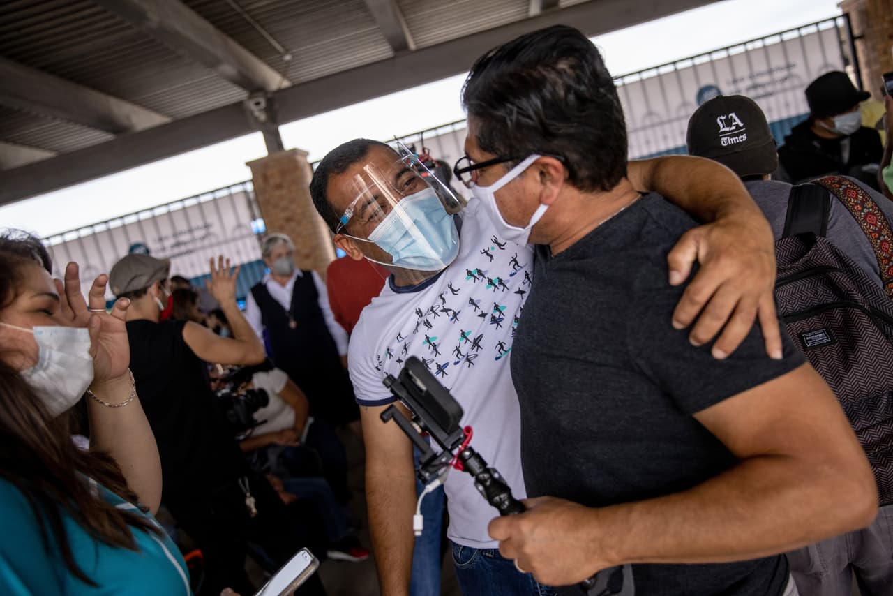 <b>Abrazo fraterno. </b>Un inmigrante y los voluntarios se abrazan después de que a un grupo de al menos 25 solicitantes de asilo se les permitió cruzar oficialmente desde un campamento de migrantes en México a los Estados Unidos el 25 de febrero de 2021 en Brownsville, Texas