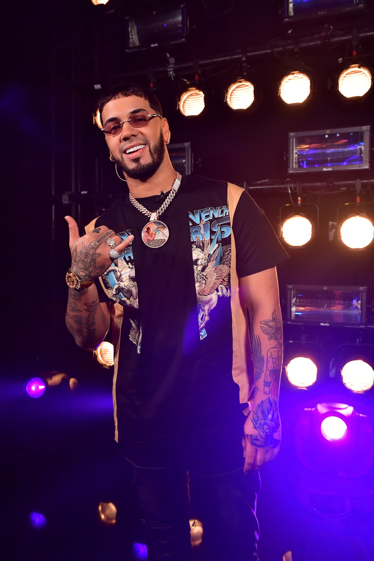 Anuel llegó usando sus clásicos lentes oscuros, además de otros accesorios como un gran reloj, anillos y una enorme cadena al cuello.