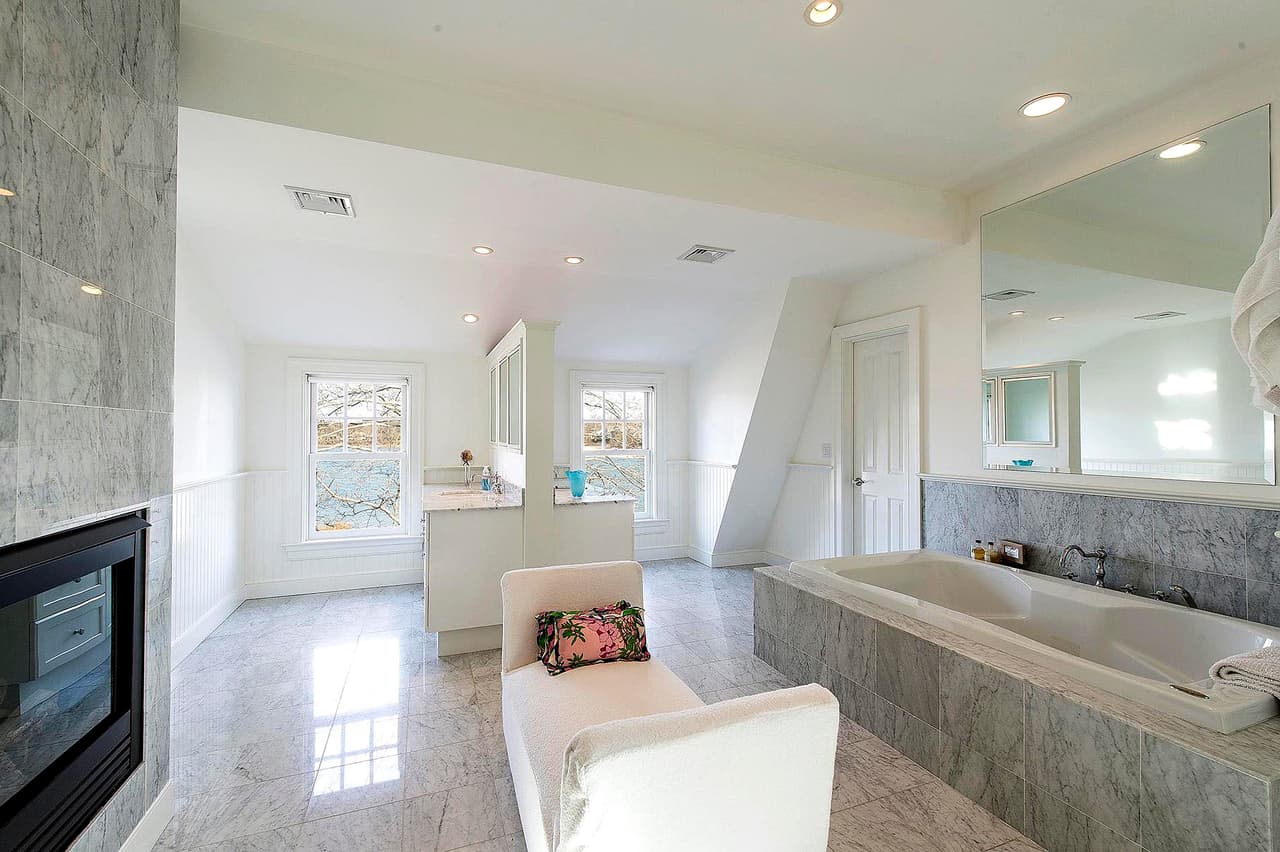 Hay un
<b> baño de mármol</b> con tocador de doble cara y bañera empotrada.
<br>