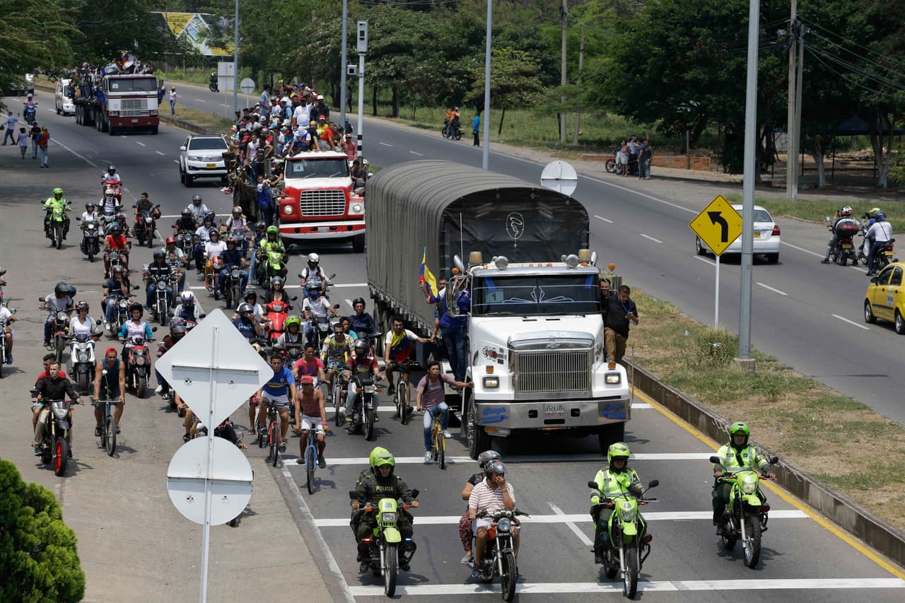 Un camión con ayuda humanitaria seguido de otro cargado con manifestantes se dirige a un puesto fronterizo entre Colombia y Venezuela en Cúcuta.