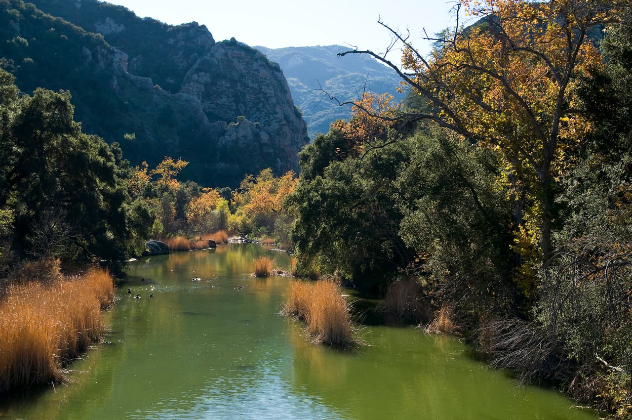 <b>California.</b>
<br>
<br>
<b>Malibu Creek,</b> en realidad, no se trata de un lago natural. En 1903, ciudadanos ricos de Los Ángeles crearon la presa y el lago como coto de caza y pesca para los miembros de un club de campo. El club floreció durante un tiempo, pero finalmente se vino abajo.
<br>
<br>En 1946, 20th el estudio cinematográfico Century Fox compró el lago y una gran franja de terreno para filmar películas, de ahí el nombre.