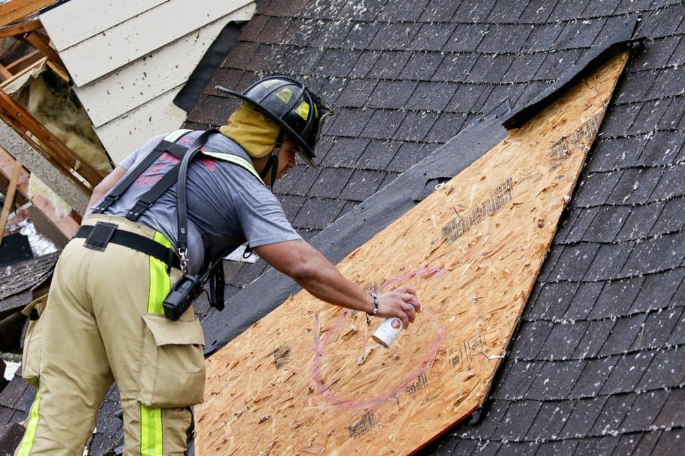 Un bombero marca una tabla después de limpiar una casa afectada por el paso de un tornado en Birmingham, Alabama.