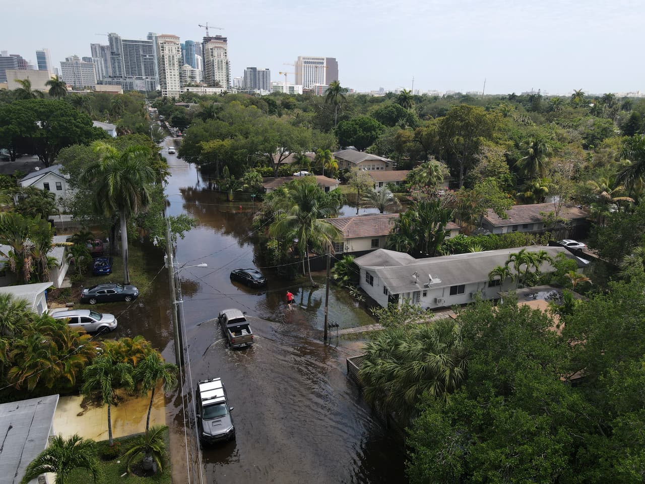 En esta foto tomada con un dron, camiones y un residente a pie se abren camino a través de las inundaciones en el vecindario Sailboat Bend de Fort Lauderdale, Florida, el jueves 13 de abril de 2023. Más de 25 pulgadas de lluvia cayeron en el sur de Florida desde el lunes, provocando inundaciones generalizadas.