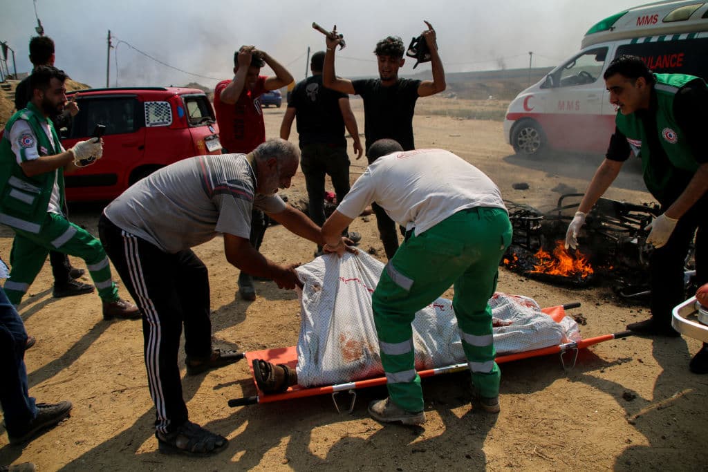 ADVERTENCIA: IMÁGENES SENSIBLES. Paramédicos transportan los cuerpos de dos jóvenes palestinos muertos al ser impactada la motocicleta en la que viajaban por un ataque israelí en la Franja de Gaza este sábado, en represalia al ataque de Hamas.