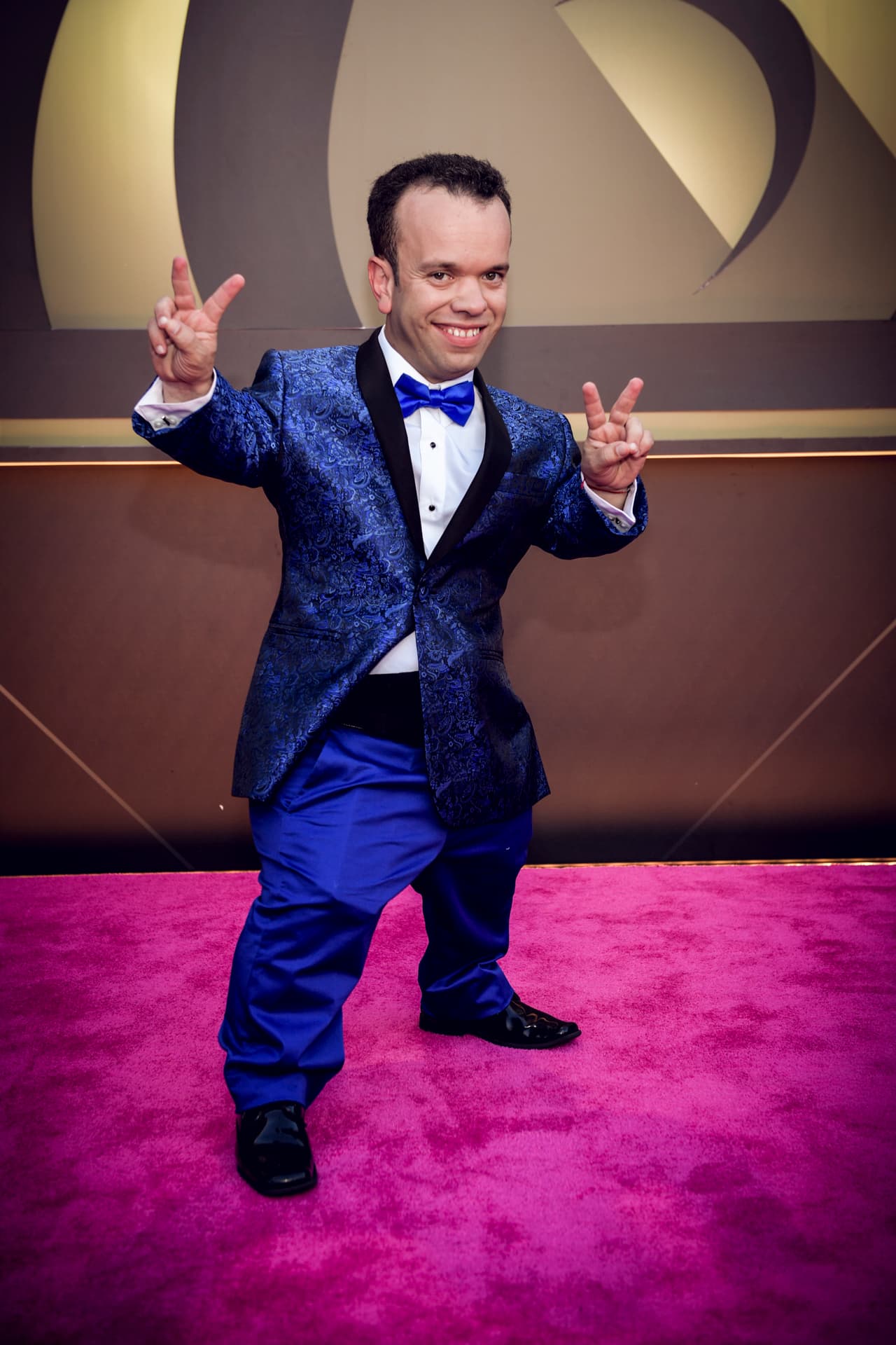 Carlitos el productor y su llamativo traje azul eléctrico.