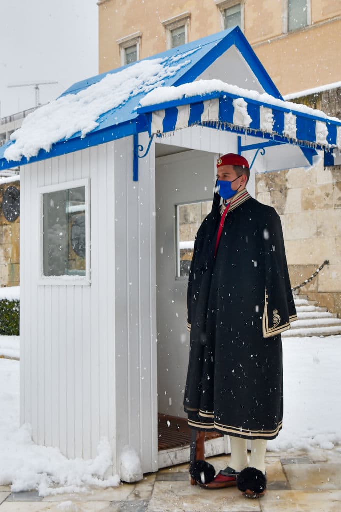 Un guardia presidencial realiza un cambio de guardia ceremonial durante una fuerte nevada.