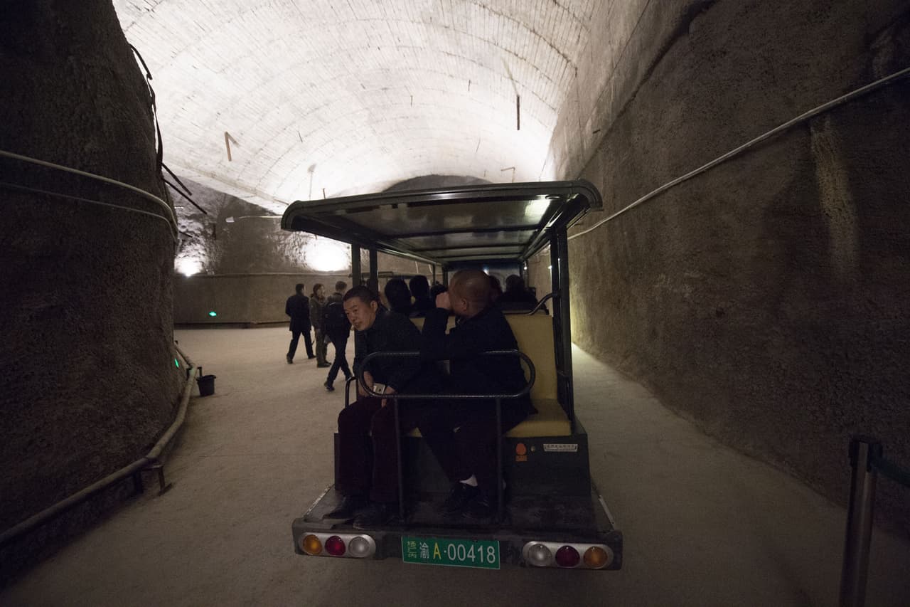 En 1967, tres años después del primer ensayo de una bomba nuclear completado con éxito por China, comenzaron las obras. Durante 17 años, 60,000 jóvenes soldados trabajaron día y noche. "Un colega activaba los explosivos. Luego, perforábamos la roca con máquinas. En cualquier momento todo podía derrumbarse", recuerda el exsoldado Chen Huaiwen, que trabajó en las obras y ahora tiene 70 años. En la foto, un grupo de visitantes recorre los túneles en un pequeño vehículo para turistas.