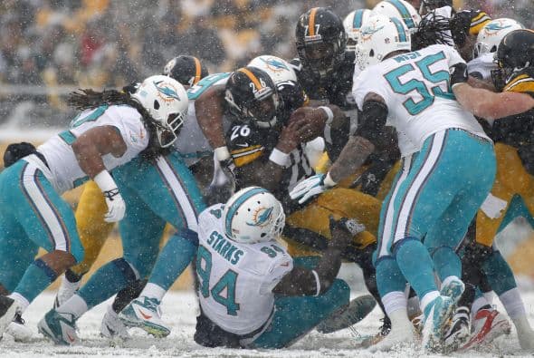 Los fanáticos de los Dolphins ya no hablan de la controversia Incognito/Martin, ni si Ireland o Philbin estarán con el equipo en el 2014, sino que pasan horas calculando… ¡porque tenemos chance de ir a los playoffs! Al principio de la temporada, y sobre todo, después de perder -casi deshonrosamente- contra Tampa Bay y Buffalo, los comentarios sobre Miami eran negativos. Qué si las novatadas, qué si Tannenhill, qué si el running game, qué si la línea ofensiva, que si… qué se yo… Pero ahora, las cosas han cambiado y solo se mencionan las posibilidades que tenemos de jugar en enero. ¡Ay, bendito! Bueno, después de este encontronazo con los portadores de las terribles toallas amarillas, donde salimos vencedores … por media pulgada… 34-28, ya todo me parece posible. Arriba Tannenhill (20 de 33, para 200 yds); arriba Wake and Odrich; arriba Thomas (105 yds, un TD en 16 acarreos); arriba Clay con sus dos TD y arriba Philbin, que mantiene el invicto en la revisión de las jugadas (obtuvo el cambio de “incomplete pass” a TD de Hartline). ¡Arriba, Dolphins, seguimos cuesta arriba!