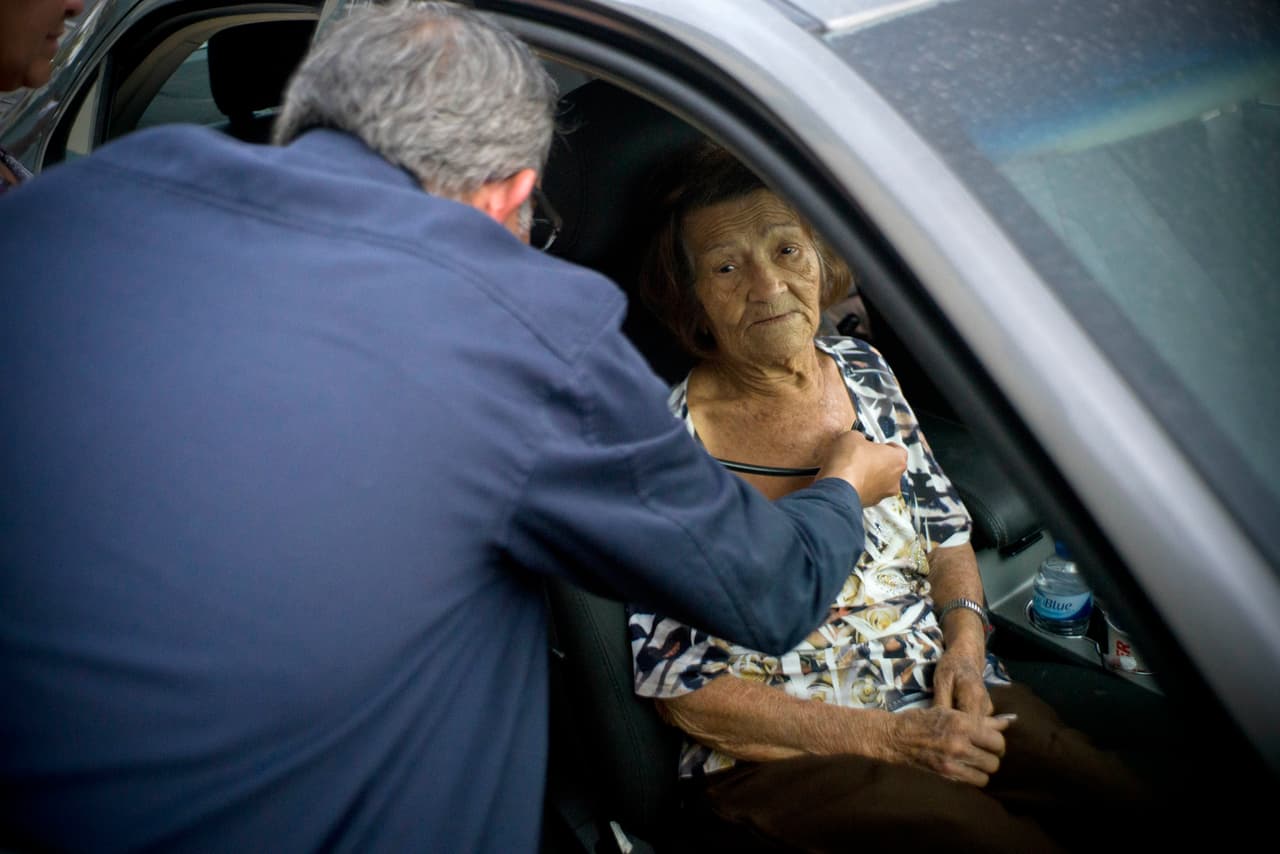 Carmen Hernández, que vive en una residencia de ancianos que carece de agua y electricidad, es examinada dentro de un coche estacionado porque en el hospital de Bayamón, Puerto Rico, no había espacio.