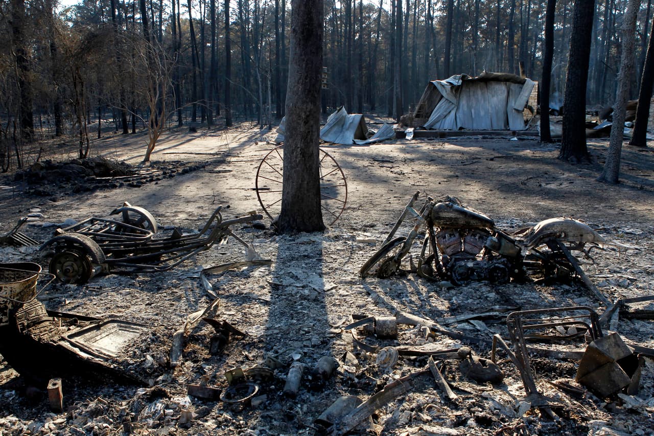 BASTROP, TX - SEPTEMBER 6: One of several classic motorcycles sits charred among the remnants of a burned down home on the east side of Lake Bastop on September 6, 2011 outside Bastrop, Texas. Several large wildfires have been devastating Bastrop County for the last two days. (Photo by Erich Schlegel/Getty Images)