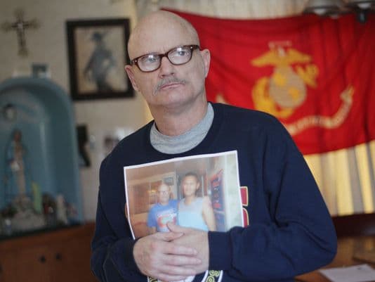 Tom sostiene una foto con su ahora esposo.