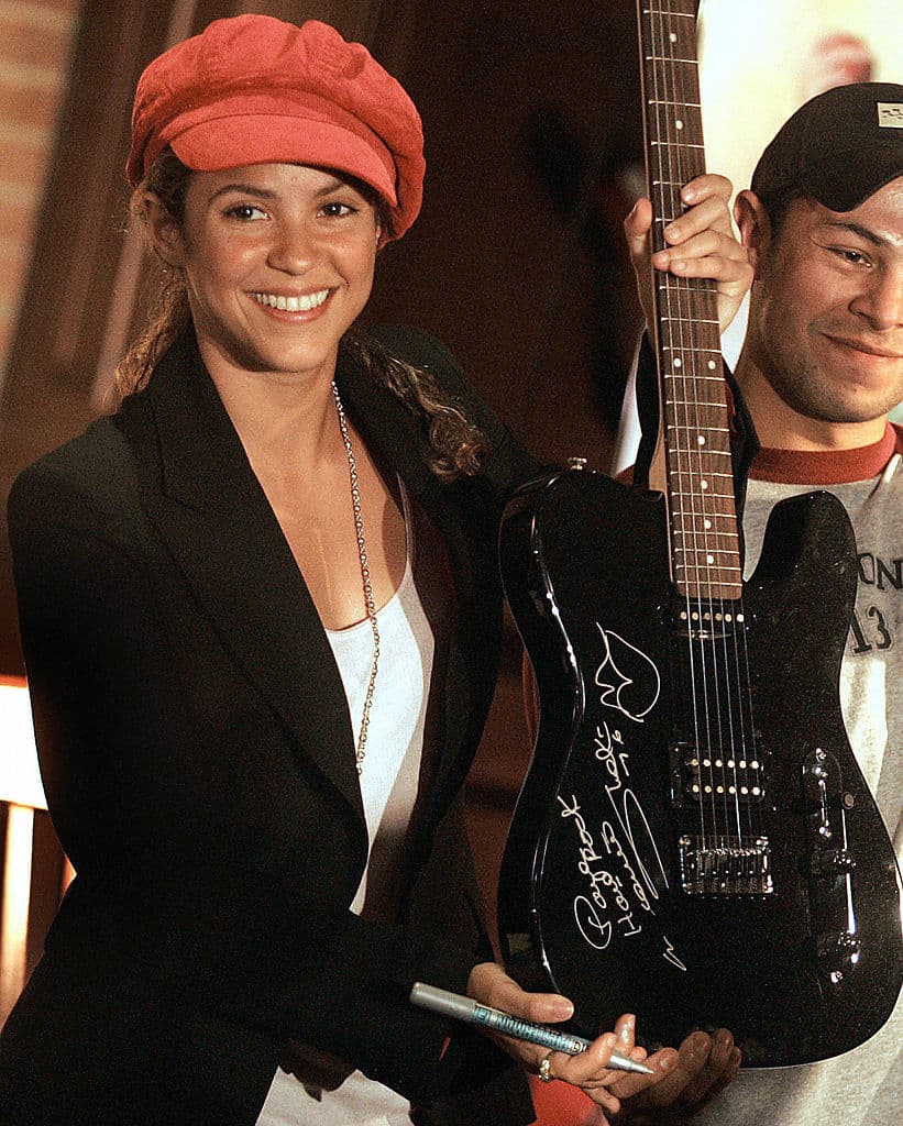 Shakira presenta una de sus guitarras autografiadas para el Hard Rock Café, durante una rueda de presna presentando su fundación, Pies descalzos, en Bogotá, Colombia, 2006.