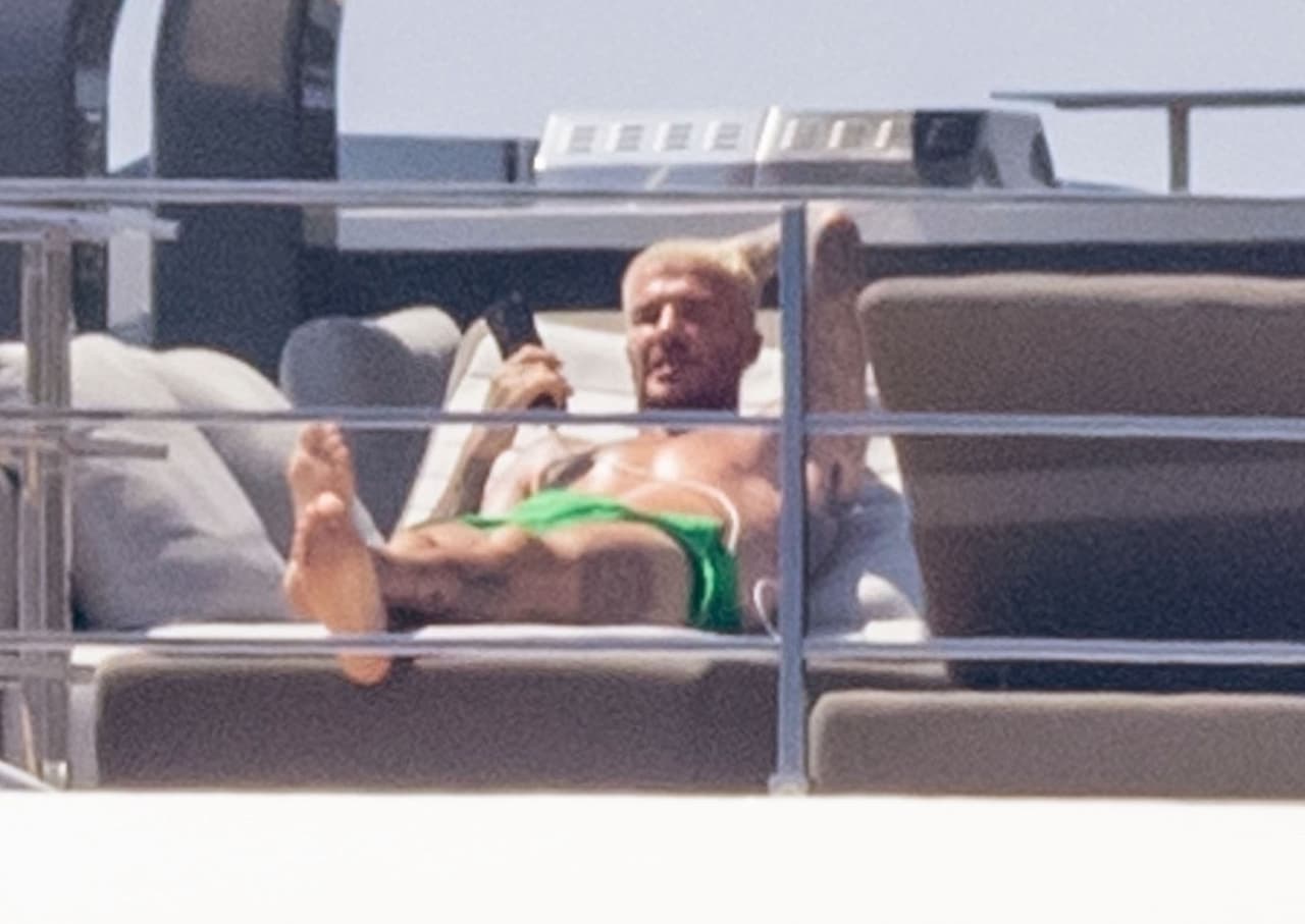 Con un short verde tomaba el sol mientras veía como sus hijos se tiraban del yate al mar.