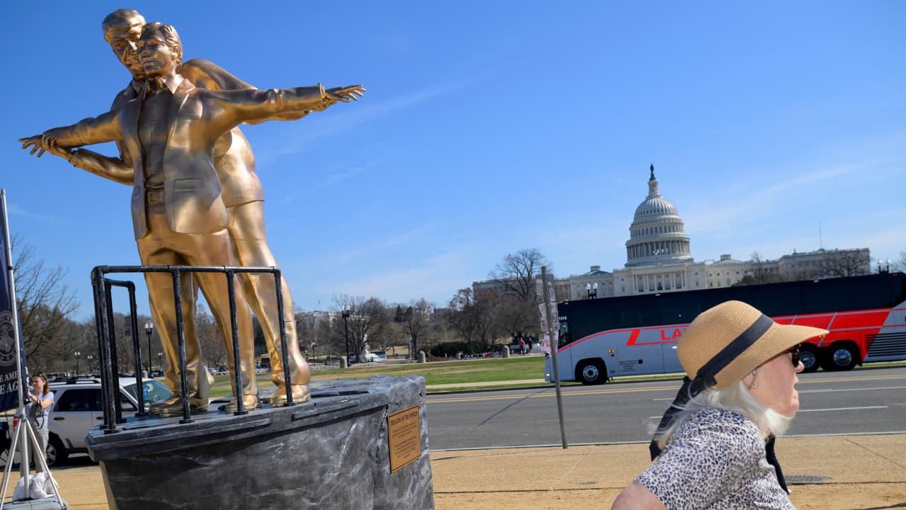 La gente se detiene ante una estatua inspirada en la película Titanic que representa al presidente Donald Trump y a Jeffrey Epstein en el National Mall.