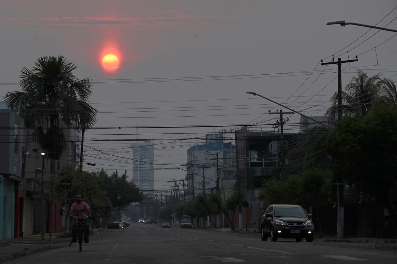 El sol, velado por el humo, cubre la ciudad de Porto Velho, estado de Rondonia, Brasil. Brasil dice que aviones militares y 44,000 tropas estarán disponibles para combatir incendios arrasando partes de la región amazónica.