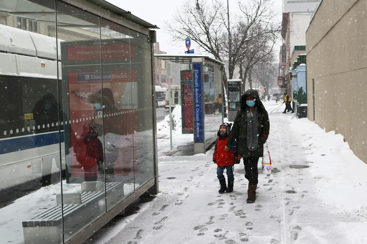 La gente camina por la acera cubierta de nieve en Flatbush