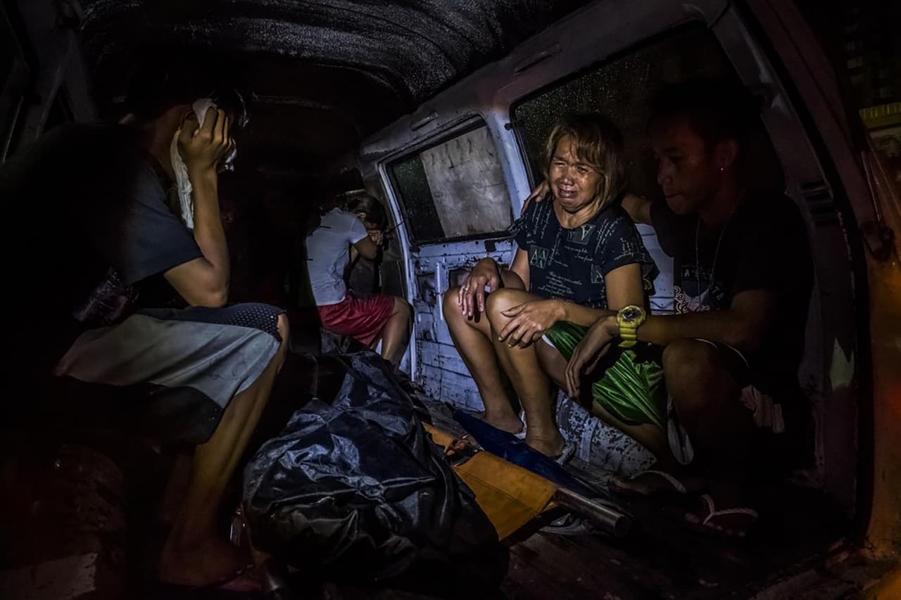 <b>La guerra contra el narcotráfico en Filipinas.</b> Nellie Díaz llora al ver el cuerpo de su esposo asesinado, Crisóstomo, un consumidor de drogas que, según ella, se rindió poco después de la elección del presidente Duterte. Padre de nueve hijos, trabajaba barnizando gabinetes. En medio de la represión contra la droga, su esposa consideró inseguro que durmiera en casa. Le dispararon delante de varios de sus hijos.