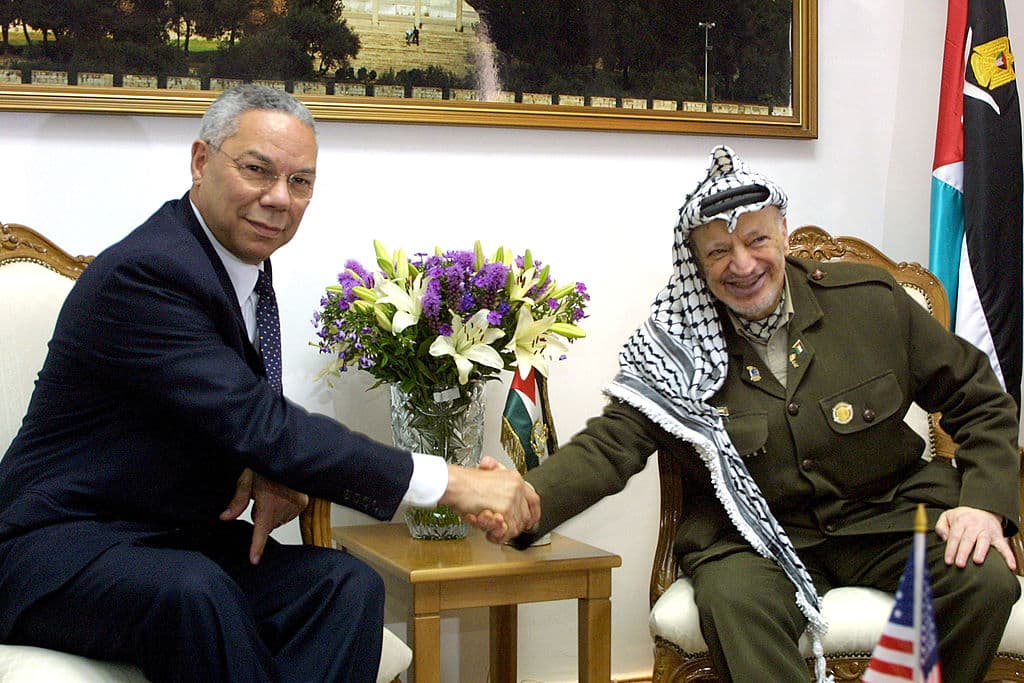 <b>Una imagen histórica.</b> Powell (izquierda) estrecha la mano del entonces presidente palestino, el fallecido Yasser Arafat, el 28 de junio de 2001 al comienzo de su reunión en la sede de Arafat en Muqaata, Cisjordania.