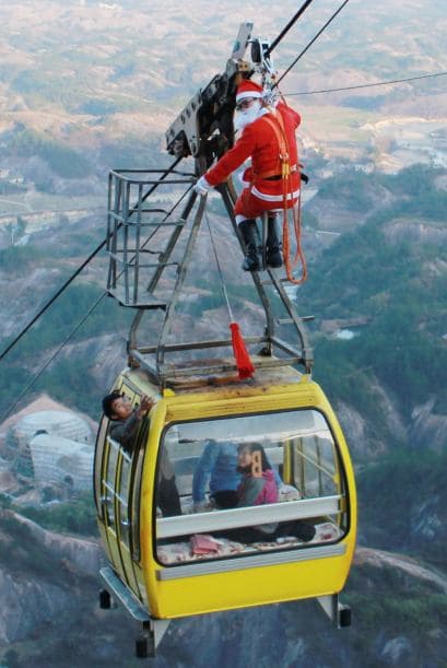 Santa no tiene límites y tampoco miedo a las alturas por eso decidió colgarse de un teleférico para entregar regalos de navidad en el centro de China.