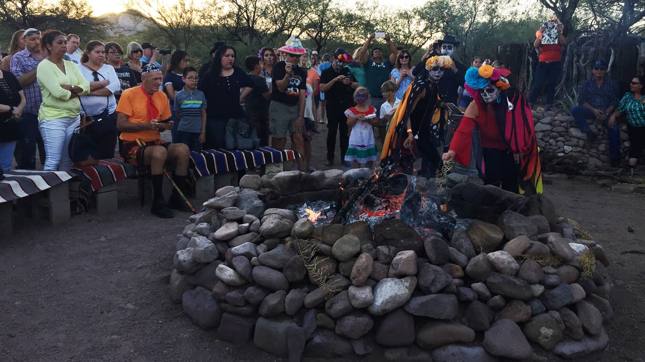 Las "Catrinas" echan a una fogata los papeles con los nombres de personas fallecidas que fueron escritos por sus familiares presentes.