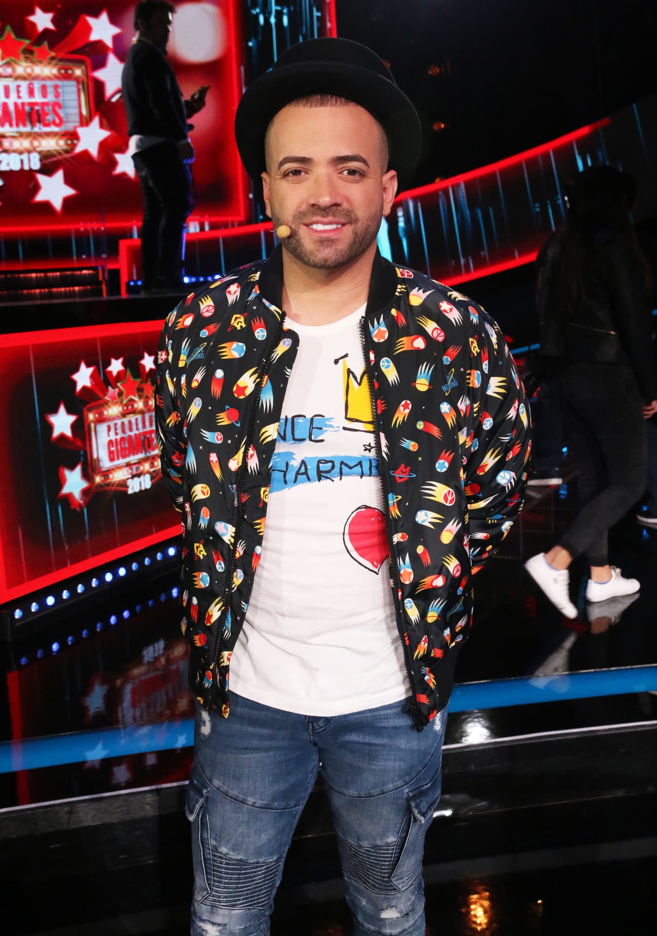 Para esta ocasión eligió una chamarra con estampado de cometas de la colección Love Moschino y una t-shirt icónica de la diseñadora inglesa Vivienne Westwood "Prince charming" de edición limitada. Además repitió el sombrero de copa para completar su 'look'.