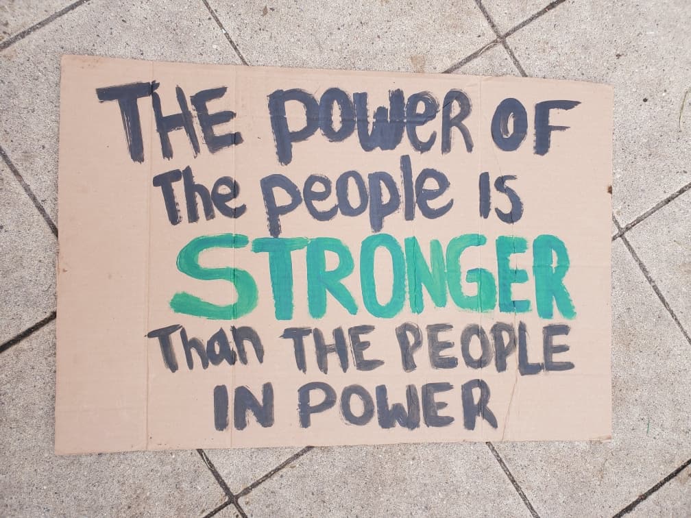 El póster dice, "El poder de la gente es más fuerte que el de la gente en poder".