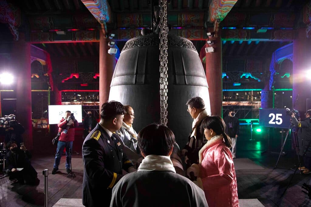 Siguiendo una tradición de año nuevo, varias personas golpean una gran campana Seúl.