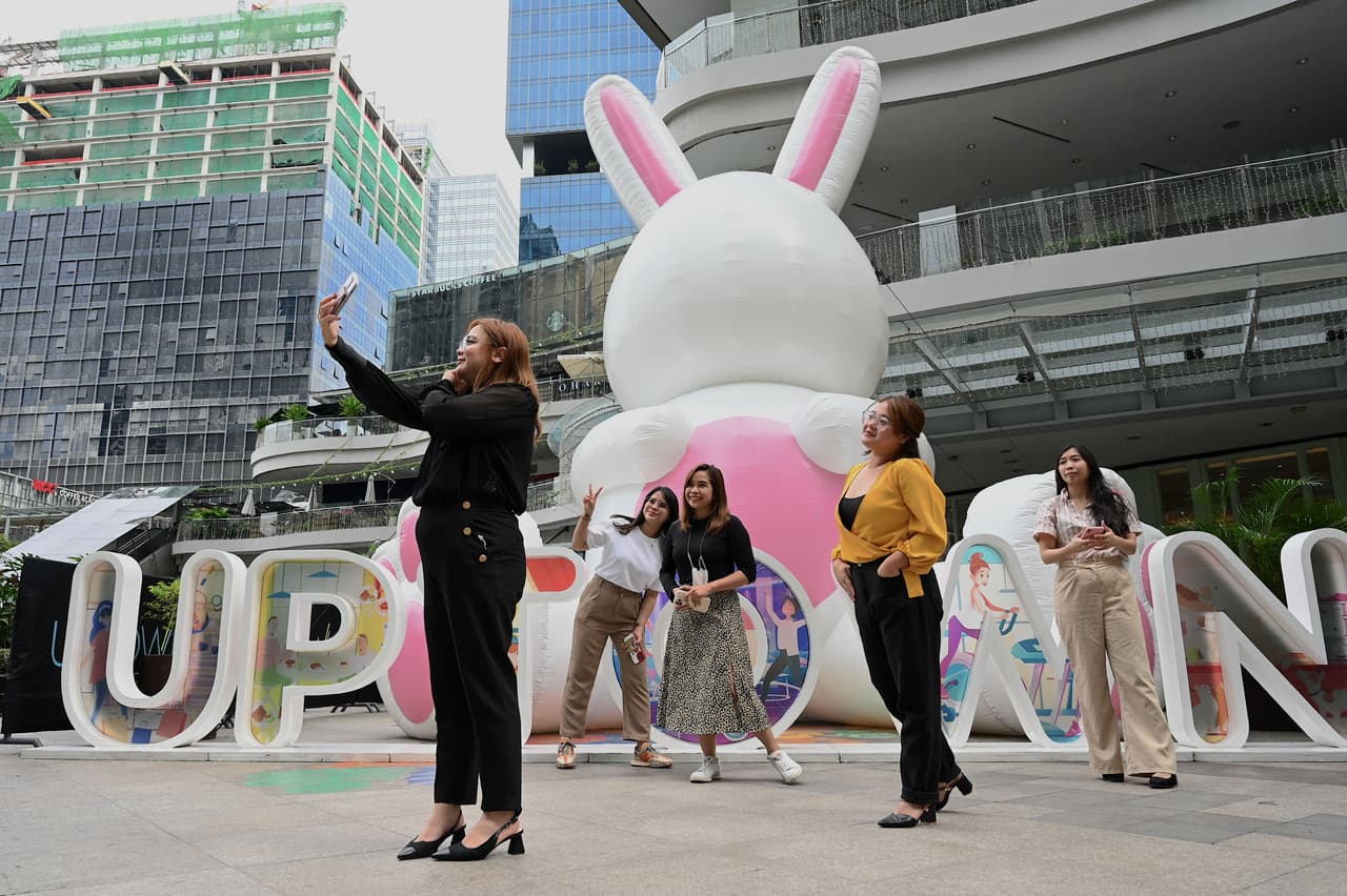 Personas posan junto a un conejo gigante colocado en un centro coercial en Taguig, Filipinas, este 16 de enero de 2023.