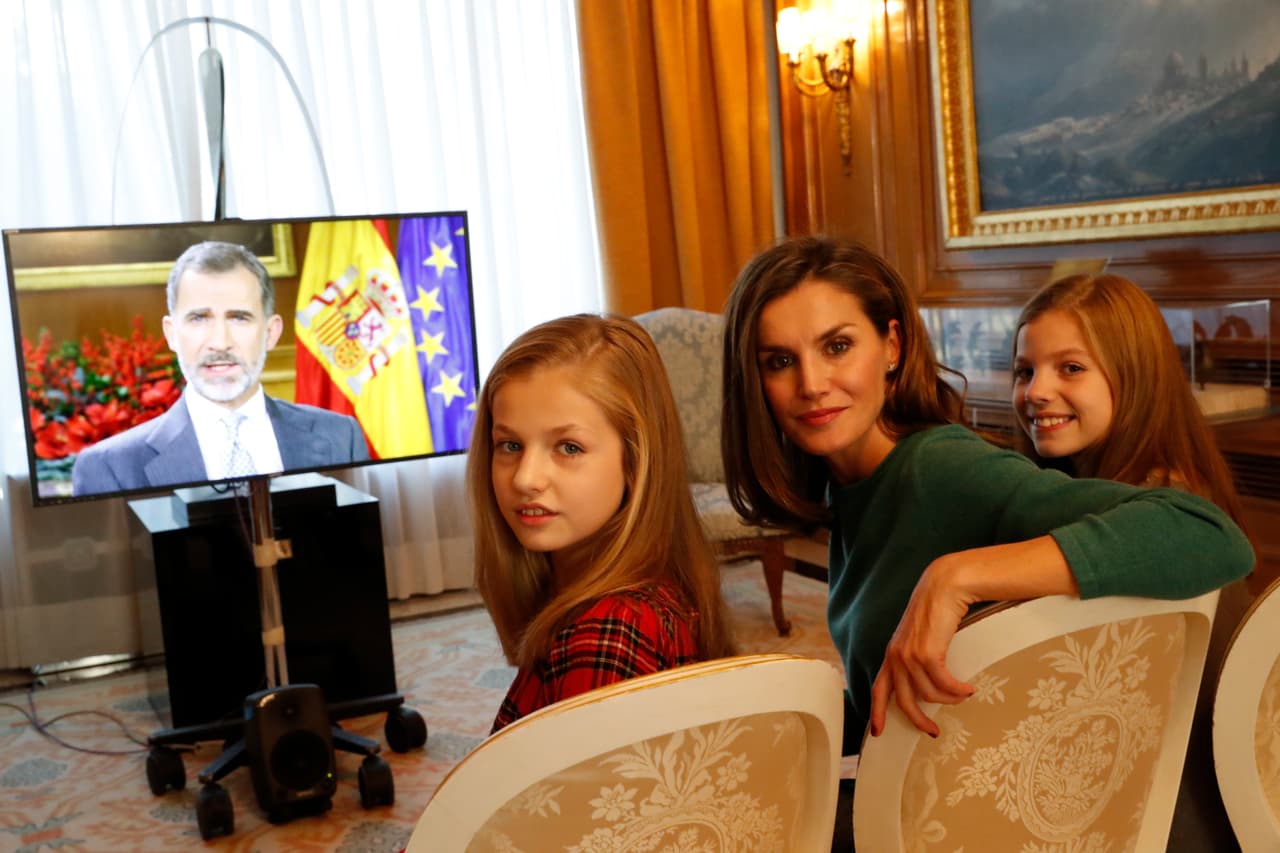 Aquí una imagen de las infantas con su madre, la reina Letizia, mientras se ve a su padre, el rey Felipe VI, haciendo su alocución televisiva que posteriormente es analizada con detalle por la prensa española, en busca de claves para interpretar la opinión de la casa real sobre los problemas del país, como las tensiones independentistas o el desempleo.