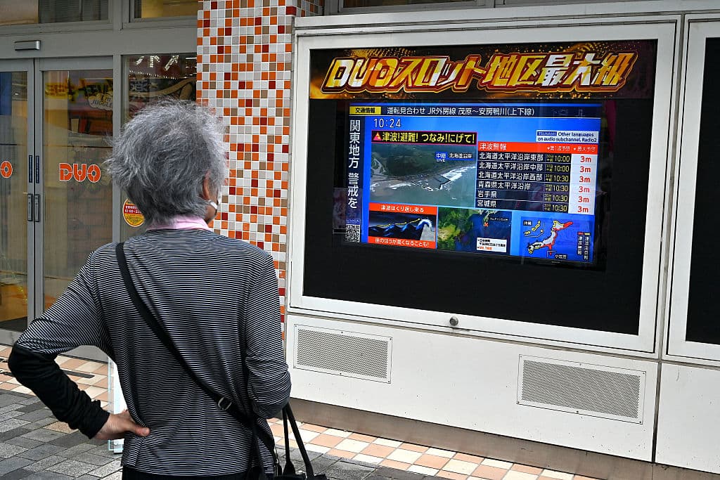 Una mujer ve las noticias del tsunami en Japón. (Photo by Richard BROOKS and Richard A. BROOKS / AFP) (Photo by RICHARD BROOKS,RICHARD A. BROOKS/AFP via Getty Images)