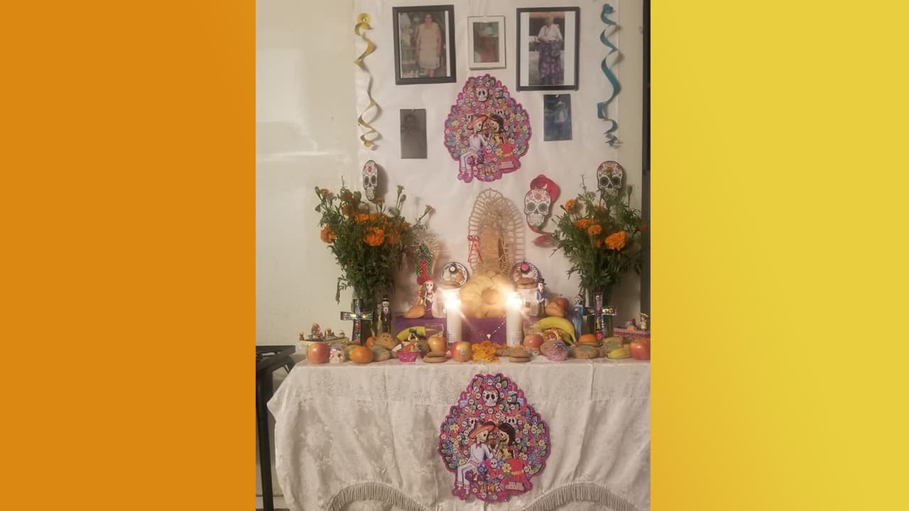 Geni Flores hizo un altar de muertos muy original al usar colores claros y colocar las fotos de sus seres queridos en la pared. La imagen de la Virgen de Guadalupe predomina en su ofrenda.