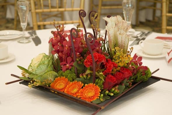 Audaz. Rompe con todas las reglas y desarma ese bonito ramo de flores que te regalaron. Quítales el tallo, intercálalas y súmale elementos inesperados a tu arreglo, como la col que se ve en la foto.