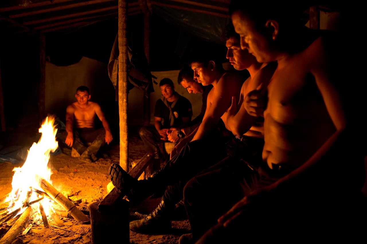 Un grupo de policías se sientan alrededor de una fogata que se construyó dentro del campamento al que llegaron a inspeccionar. Más de 1,000 agentes y soldados participaron en los operativos.