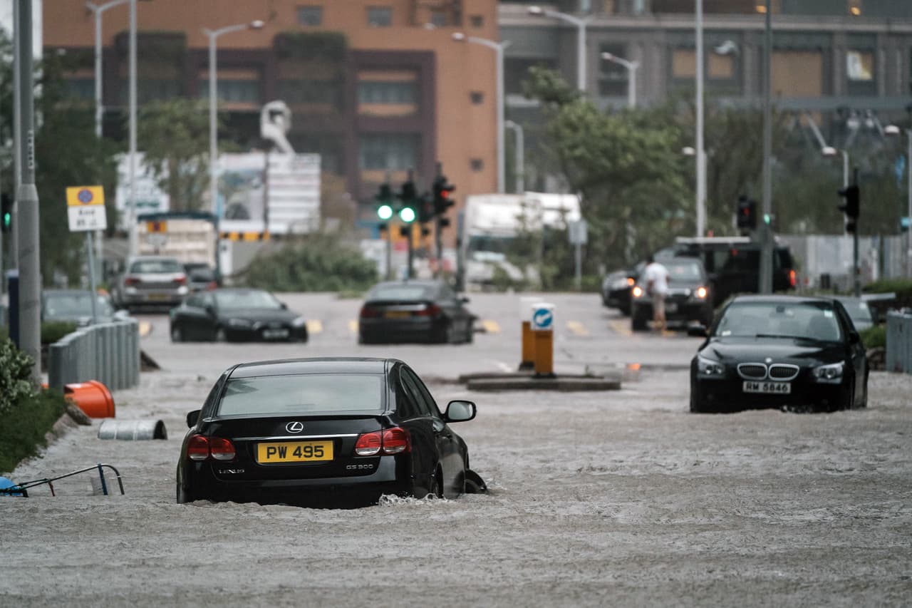 Automóviles que fueron arrastrados por el tifón en Hong Kong. Puertos, refinerías de petróleo y plantas industriales en el área han sido cerradas.