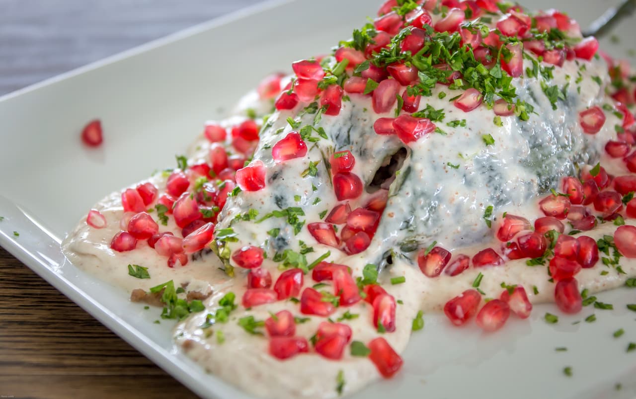 Cabe señalar que el relleno es clave en la receta, así como salsa de nogada que lleva nueces de castilla frescas, queso de cabra, oporto o jerez y leche. Para cerrar con brocho de oro, se necesita granada, y perejil chino para adornar el plato.