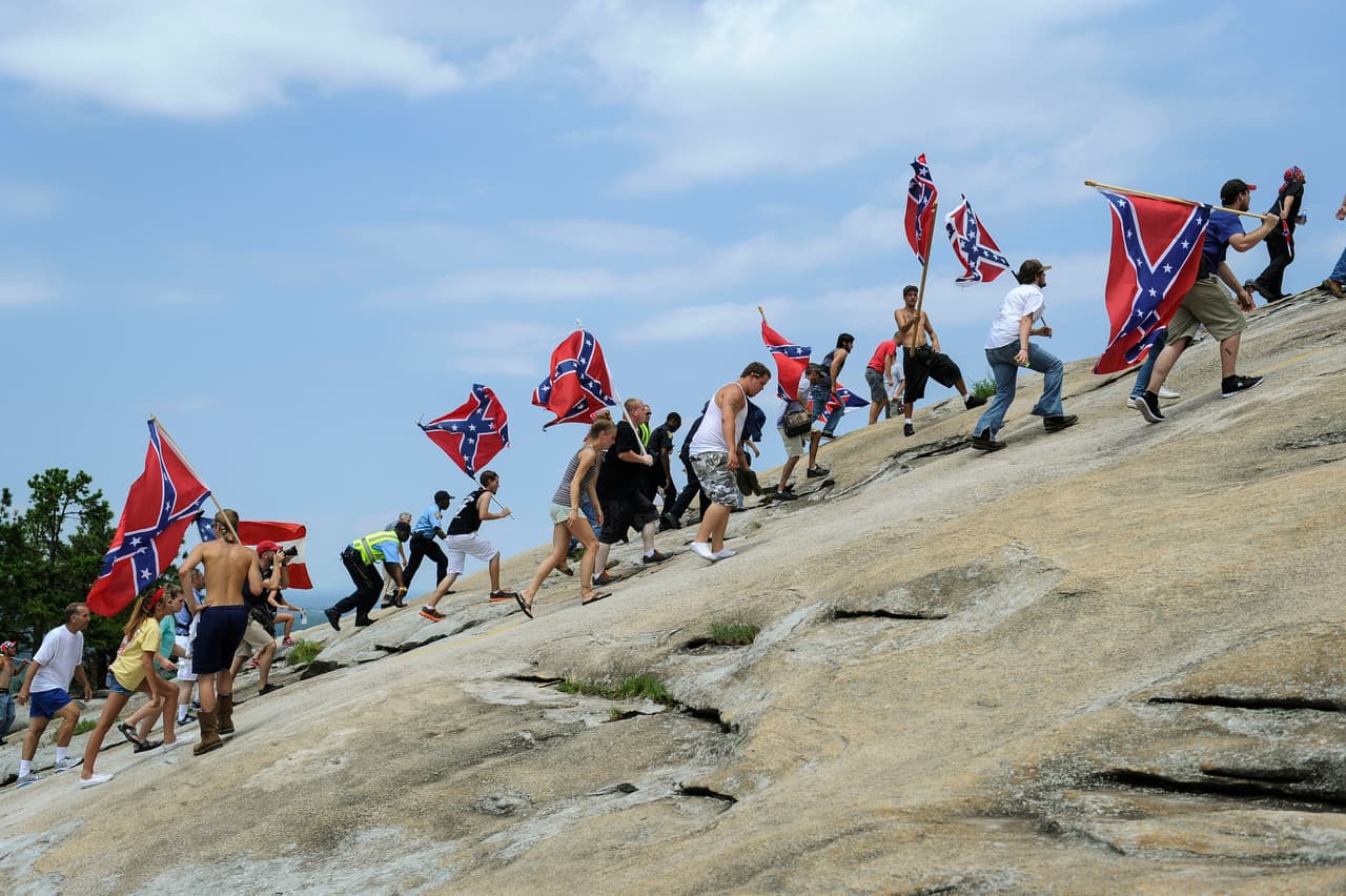 Una manifestación de partidarios de la bandera confederada escala la montaña de piedra en 2015, como protesta a lo que consideraron ataques a su herencia sureña, luego de que Carolina del Sur prohibiera el uso público de la polémica bandera. Fue la consecuencia de 
<a href="https://www.univision.com/noticias/tiroteos/lo-que-tienen-en-comun-casi-todos-los-autores-de-tiroteos-masivos-ser-hombres">una masacre en junio de aquel año en una iglesia de Charleston</a> a manos de un supremacista blanco.
<br>