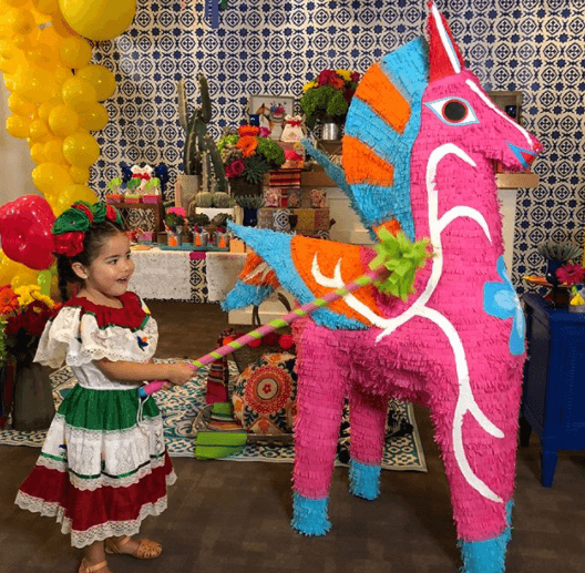 La pequeña lucía muy divertida, simulando pegarle a este simpático caballo.