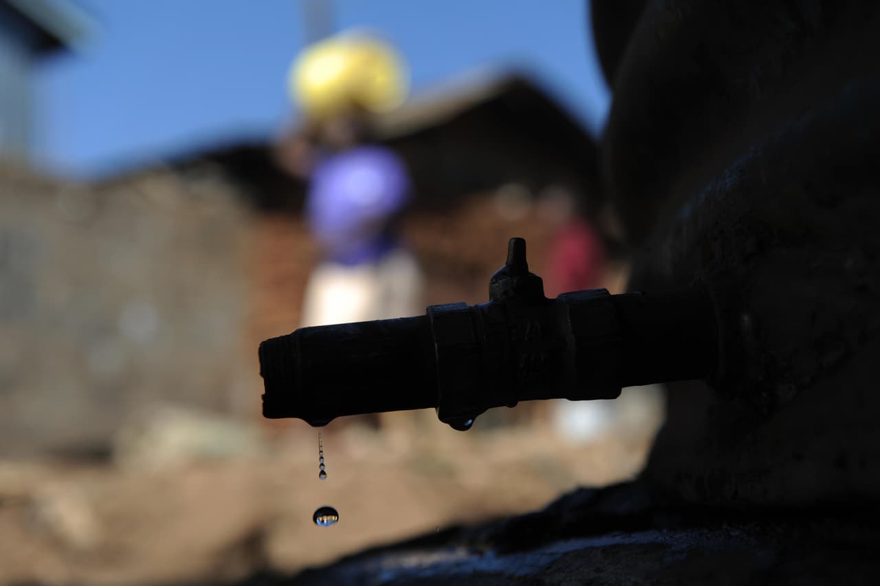 Se filtra agua de un grifo en un sitio de distribución en el barrio marginal de Kibera, en Nairobi, Kenia, el 21 de marzo, 2009. Los residentes de uno de los mayores barrios pobres de África hacen fila todos los días para buscar el agua con la que cocinan y lavan. El acceso al agua potable en el África subsahariana es peor que cualquier otra área en el continente africano, con sólo entre el 22% y el 34% de la población en al menos ocho países del África subsahariana que tienen acceso a agua potable. ROBERTO SCHMIDT / AFP / Getty Images