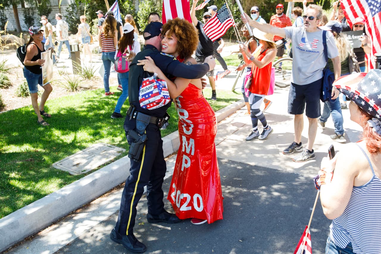 La cantante argentino-estadounidense Joy Villa abraza a un oficial de policía de Beverly Hills mientras la gente marcha en apoyo del presidente de los Estados Unidos durante un mitin WalkAway el 8 de agosto de 2020 en Beverly Hills, California.