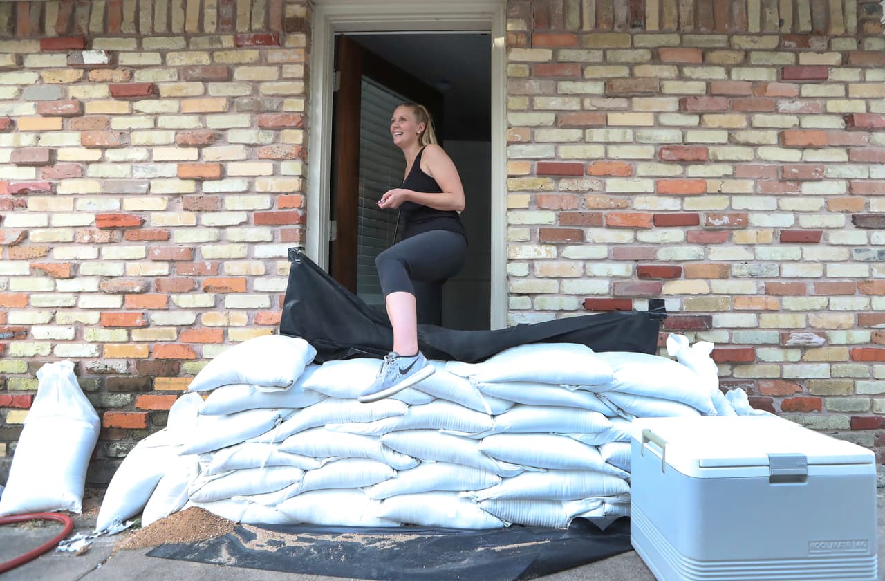 Lacey Williams sale de la puerta de su casa saltando los sacos de arena que han puesto de forma preventiva en su casa de Houston. Las autoridades de Texas han expresado su preocupación por aquellos que no han atendido las llamadas para la evacuación voluntaria.