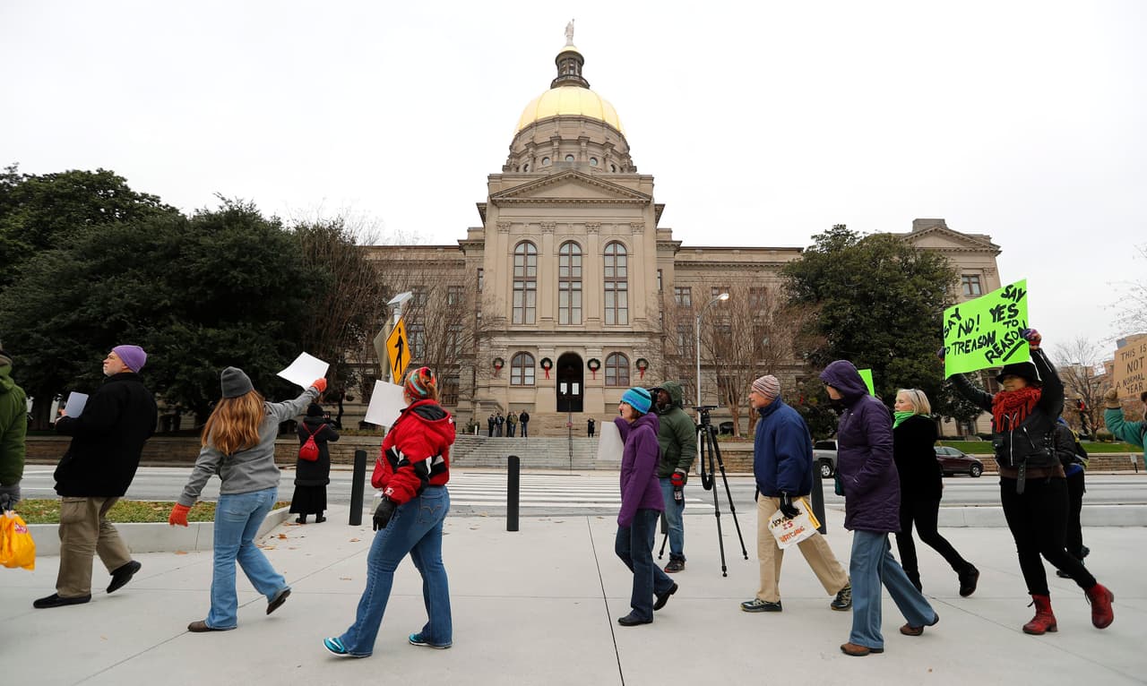 Ciudadanos estadounidenses se manifiestan afuera del Capitolio Estatal de Georgia, antes del encuentro de los dieciséis electores del estado, que emitirán sus votos este 19 de diciembre de 2016. El Colegio Electoral de EE.UU se reúne este lunes para certificar la victoria del republicano Donald Trump.