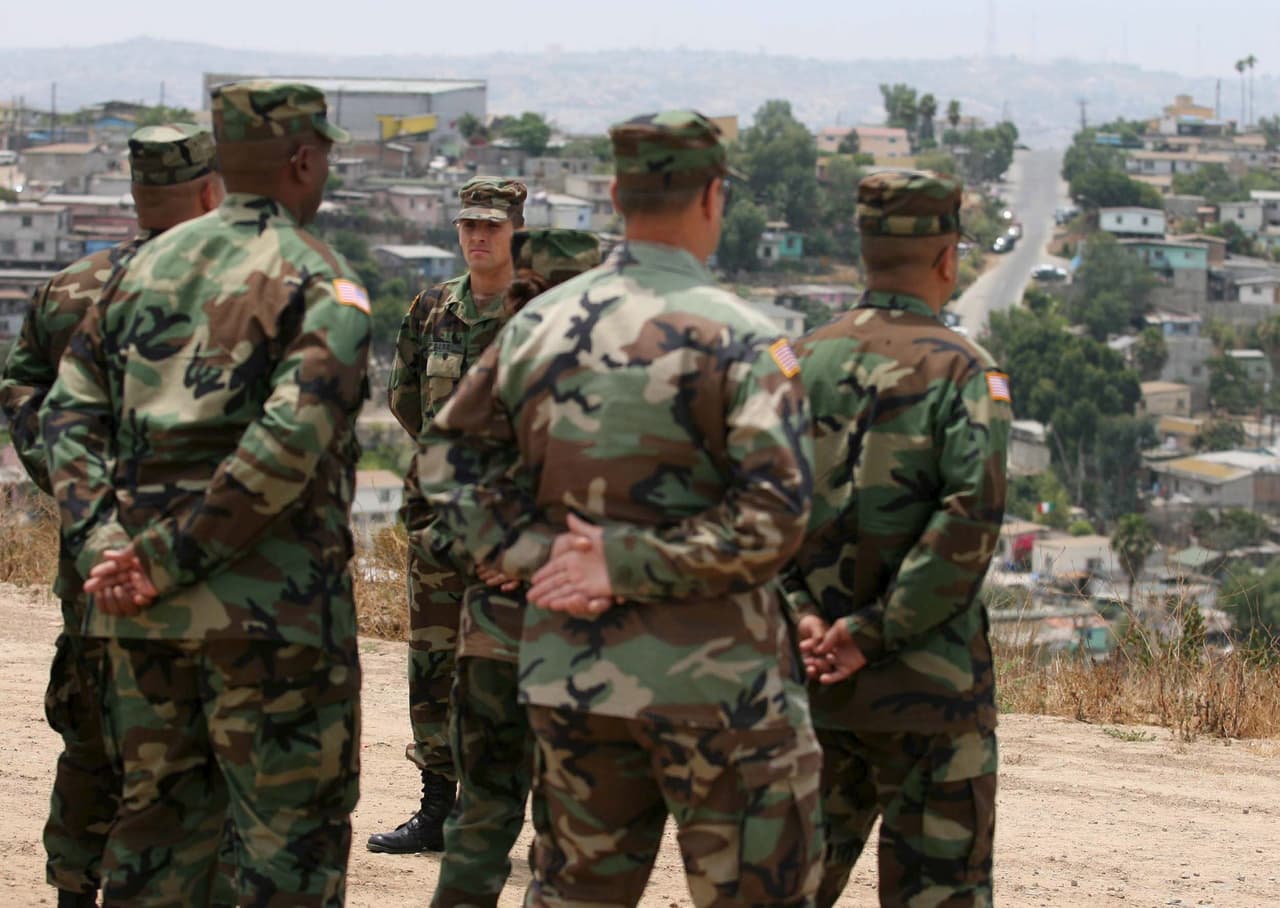 <b>En territorio estadounidense. </b>Voluntarios de la Guardia Nacional observan la ciudad fronteriza de Tijuana, México, desde territorio estadounidense, cerca de Otay Mesa, California, en julio de 2006. Eran parte de la presencia que desplegó la Guardia Nacional en California durante dos años. Ayudaron a levantar muro fronterizo.