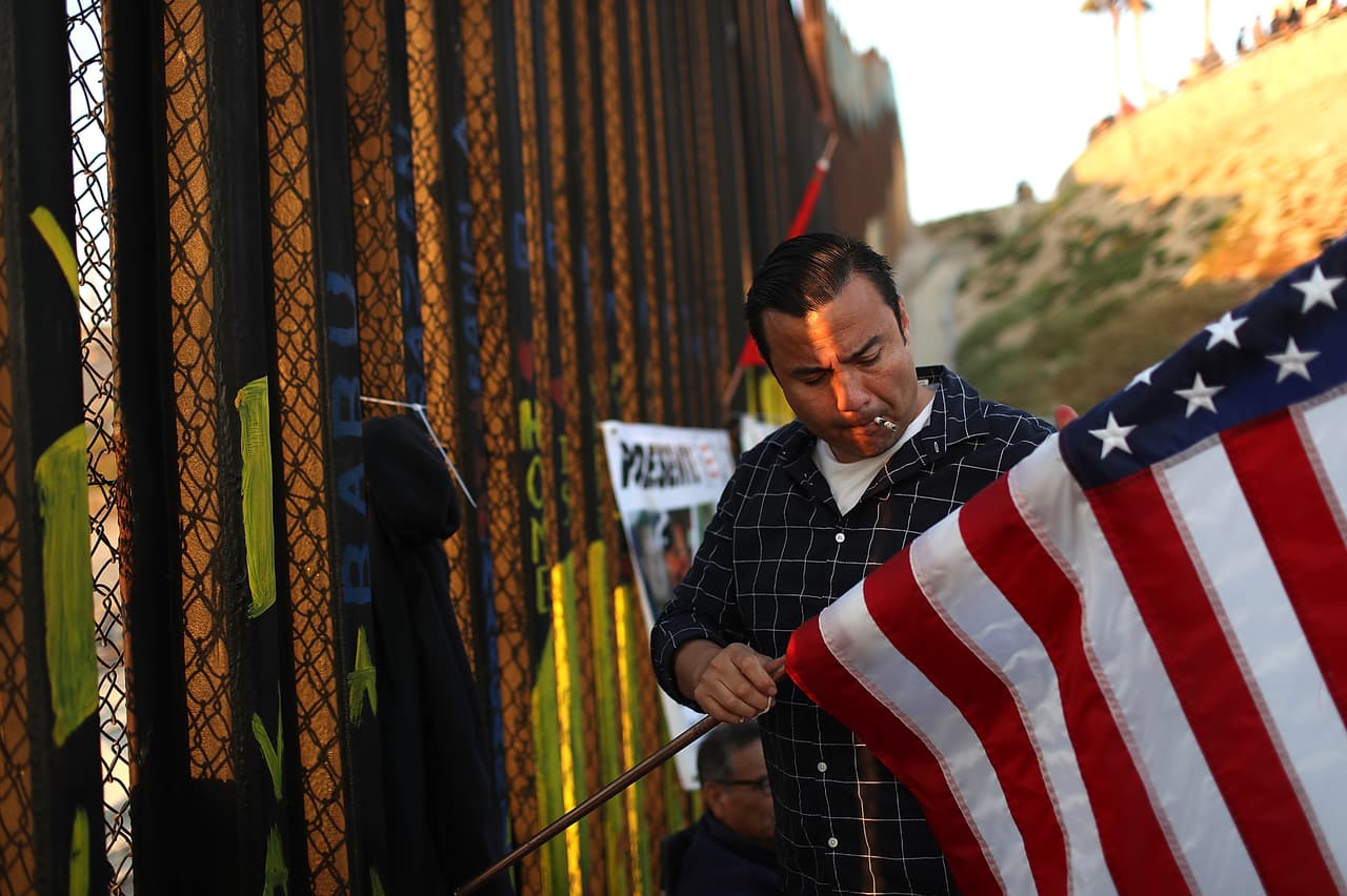 Los residentes legales permanentes que salen antes de tiempo del servicio militar o que son condenados por un crimen después de servir pueden ser deportados. Junto a varios compañeros veteranos deportados, el ex Marine Edwin Salgado celebró el 4 de julio junto a la barda fronteriza en Tijuana.