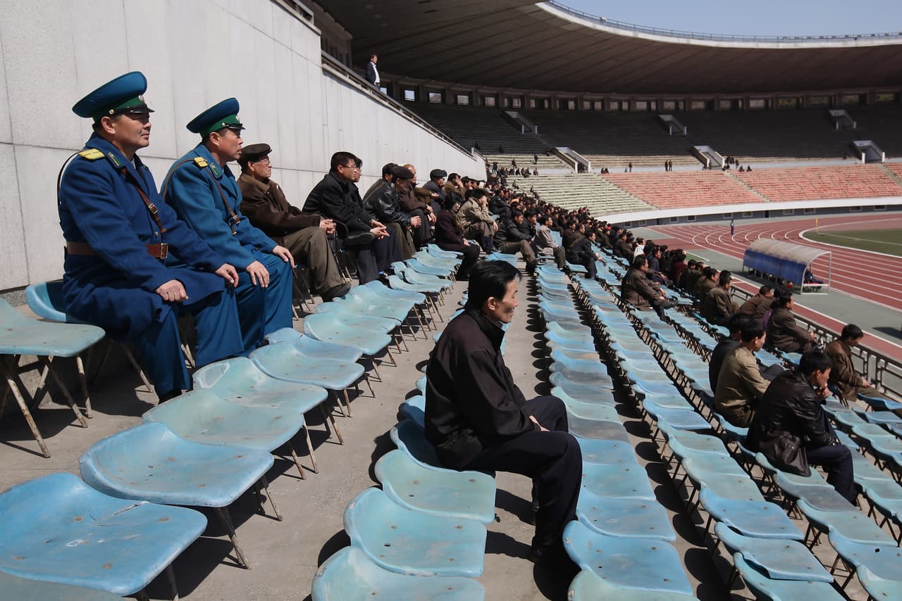 Dos policías y algunos civiles miran un partido de fútbol femenino en el estadio de Kim Il Sung de la capital norcoreana. 3 de abril de 2011.