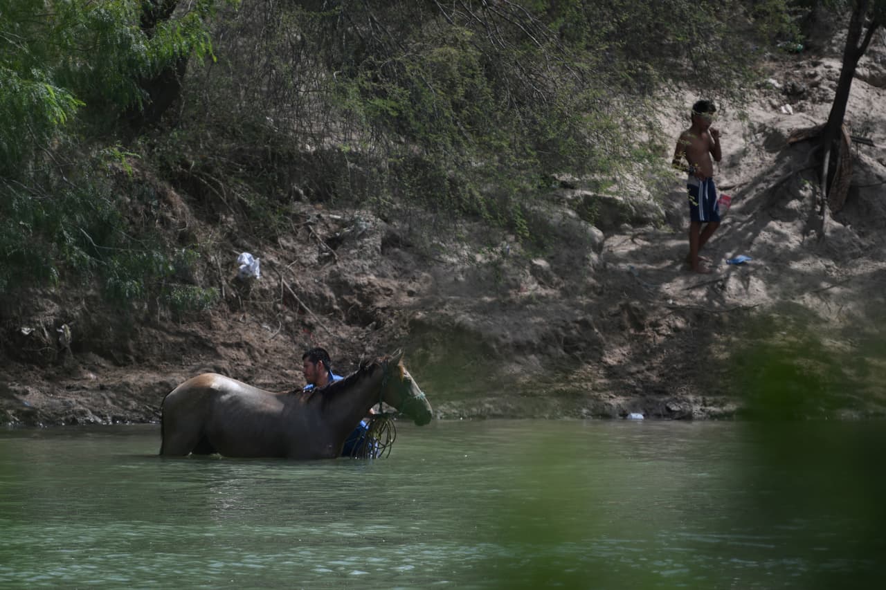 Un hombre asea su caballo en el lado mexicano del río Grande, en la frontera con Estados Unidos. A mediados de junio, las autoridades encontraron
<b> <a href="https://www.univision.com/noticias/sucesos/hallan-los-cuerpos-de-seis-adultos-y-una-nina-ahogados-en-un-canal-del-rio-grande-que-separa-el-paso-de-ciudad-juarez">los cuerpos de seis adultos y una niña ahogados</a></b> en un canal del río Grande en la zona que separa El Paso de Ciudad Juárez. Días más tarde, una cámara fotográfica capturó la dramática imagen de 
<b><a href="https://www.univision.com/noticias/america-latina/un-padre-migrante-intenta-rescatar-a-su-hija-de-la-corriente-en-el-rio-bravo-y-los-dos-mueren-ahogados">los cuerpos de un padre y su hija de casi dos años </a></b>que se ahogaron tratando de cruzar a este país para pedir asilo.
